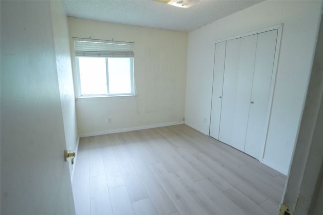 Unfurnished bedroom featuring light wood-type flooring, a closet, baseboards, and a textured ceiling | Image 13