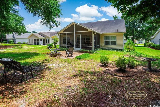 Back of house featuring a sunroom, an outdoor fire pit, a yard, and a patio | Image 30