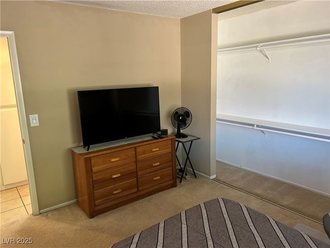 Bedroom featuring light carpet and a textured ceiling | Image 32