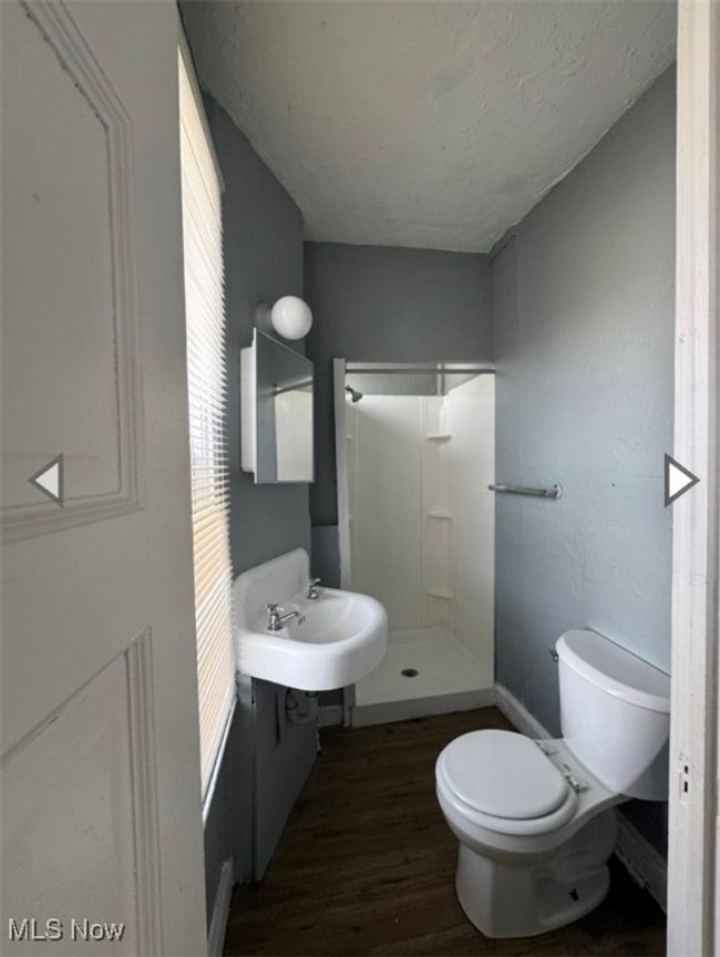 Bathroom featuring toilet, a textured ceiling, walk in shower, hardwood / wood-style floors, and sink | Image 6