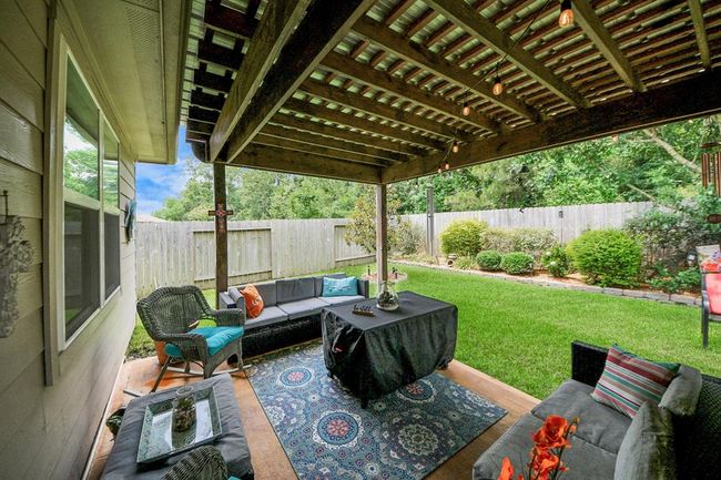 Extended covered patio open above spa looks onto beautiful landscaped yard with treeded greenspace. | Image 5