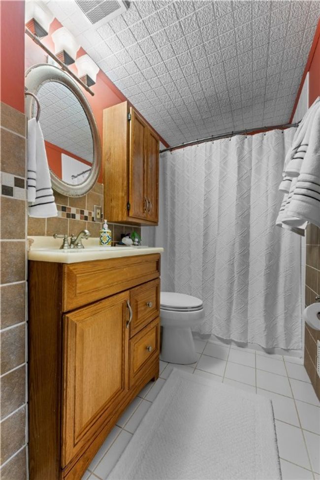 The main bath of the second floor features ceramic tile floor and bath/shower area. | Image 15