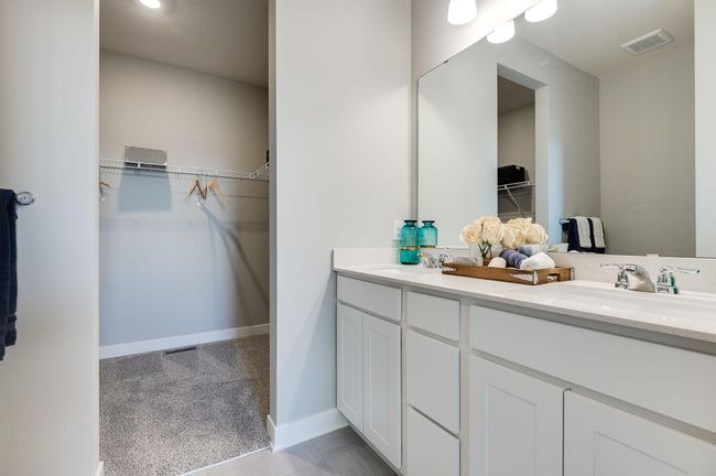 Double sinks in the primary suite and an expansive walk in closet. Photo is of a previously built model home, finishes and selections will vary. | Image 12