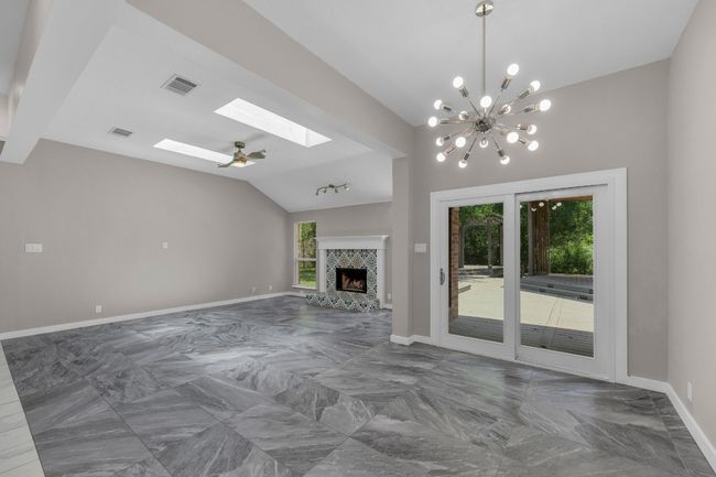 Breakfast are and living room with vaulted ceilings and a lot of natural light. | Image 8