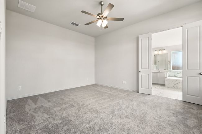 Unfurnished bedroom with carpet, ensuite bathroom, and ceiling fan | Image 20