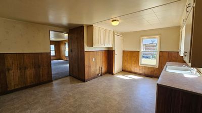 Kitchen with crown molding, wooden walls, sink, and plenty of natural light | Image 3