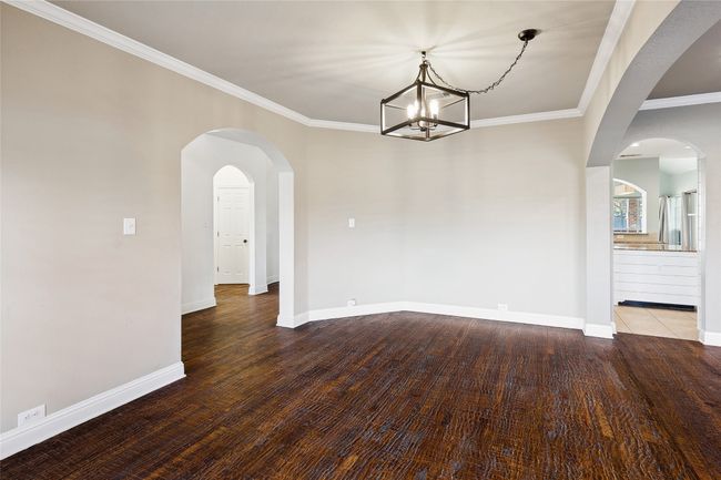 Unfurnished dining area with wood-type flooring, crown molding, and a notable chandelier | Image 27