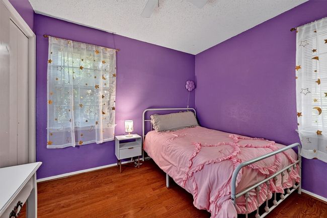 Bedroom with wood finished floors, a textured ceiling, and a ceiling fan | Image 23