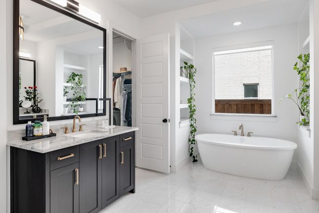 Bathroom featuring a soaking tub, vanity, recessed lighting, baseboards, and marble look tile flooring | Image 23