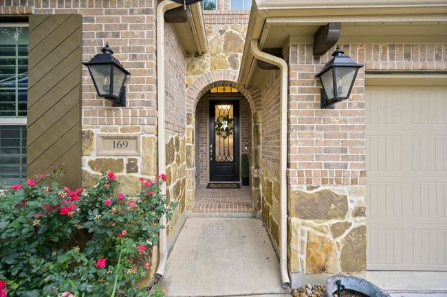 View of exterior entry featuring brick siding, stone siding, and a garage | Image 4