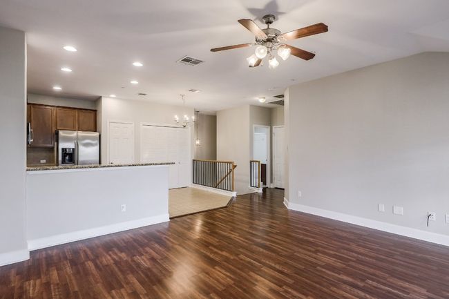 Family room view of kitchen bar with laminate wood floors, recessed lighting, a ceiling fan | Image 7