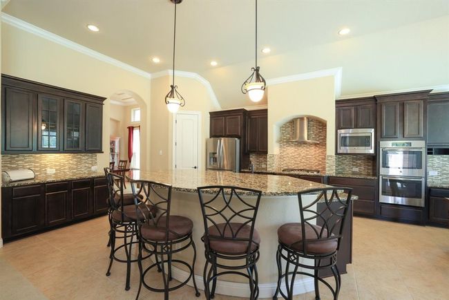 Easily fit 6 bar stools at the island. Double ovens and microwave | Image 16