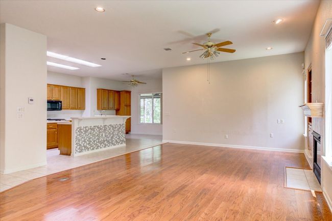 Unfurnished living room with ceiling fan, a tiled fireplace, recessed lighting, and light wood-style floors | Image 10