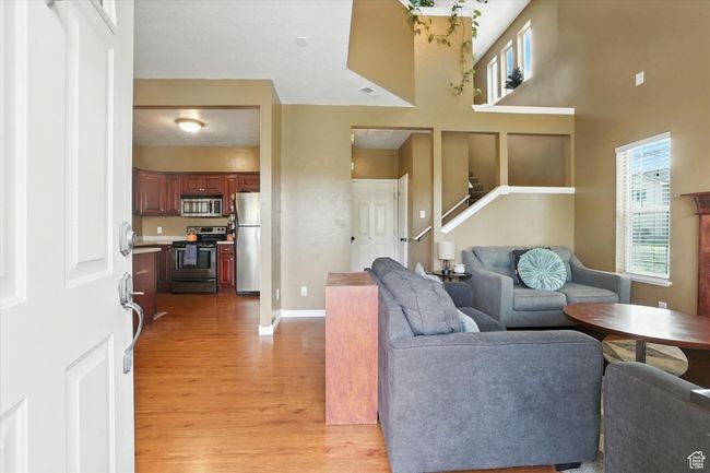 Living room featuring light wood-style flooring, stairs, and a towering ceiling | Image 4
