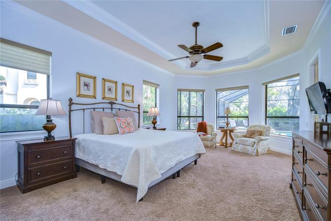 Unwind in your serene primary bedroom retreat, where natural light dances through expansive windows, embracing you in warmth and tranquility. | Image 19