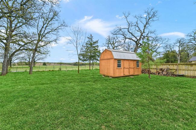 View of yard with a storage unit, a fenced backyard, and an outdoor structure | Image 29