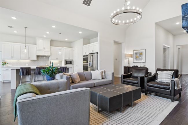 Living area featuring dark wood-style flooring, a chandelier, recessed lighting, and a towering ceiling | Image 8