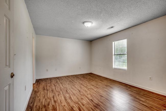Empty room with wood finished floors and a textured ceiling | Image 25