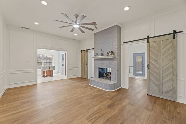 Unfurnished living room with visible vents, a barn door, and a decorative wall | Image 15