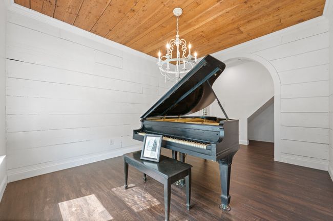 Living area featuring wood ceiling, a chandelier, wood finished floors, and arched walkways | Image 11