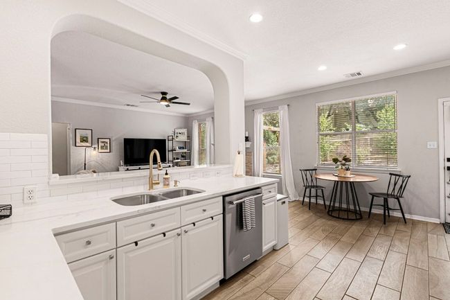 Quartz countertops shine in the kitchen with a seamless view into the living area | Image 9