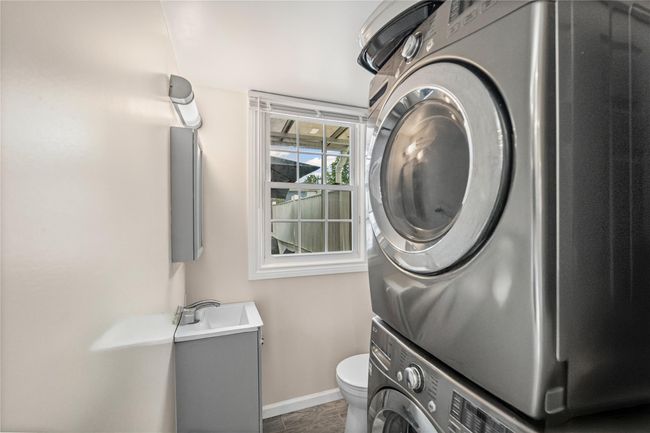Washroom with stacked washing machine and dryer and baseboards | Image 15
