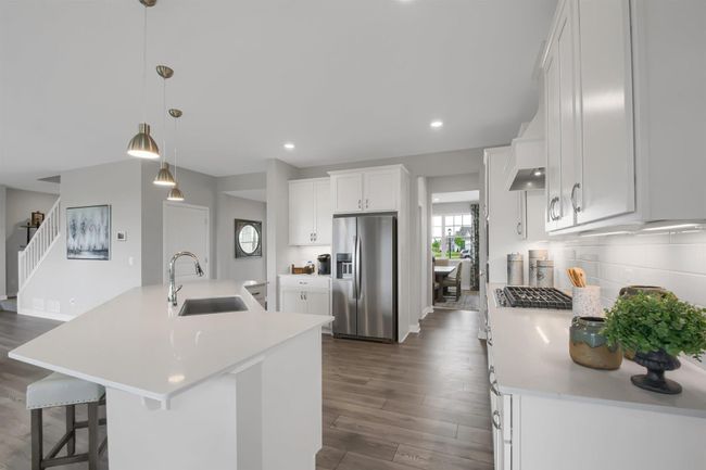 Beautiful quartz counters sprawl across this gourmet kitchen. Great for entertaining and daily living. Model photos. Options and colors will vary. | Image 4