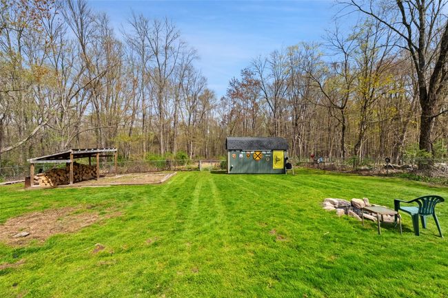 View of yard featuring an outbuilding, a storage shed, and fence | Image 35