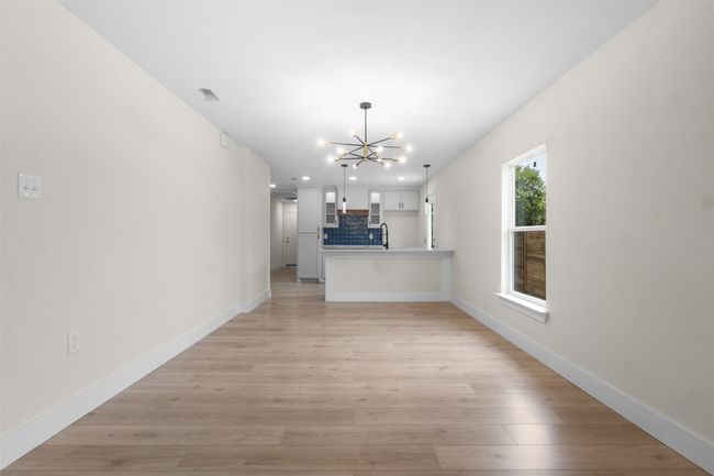 Unfurnished living room featuring a chandelier, light wood-style floors, and recessed lighting | Image 13