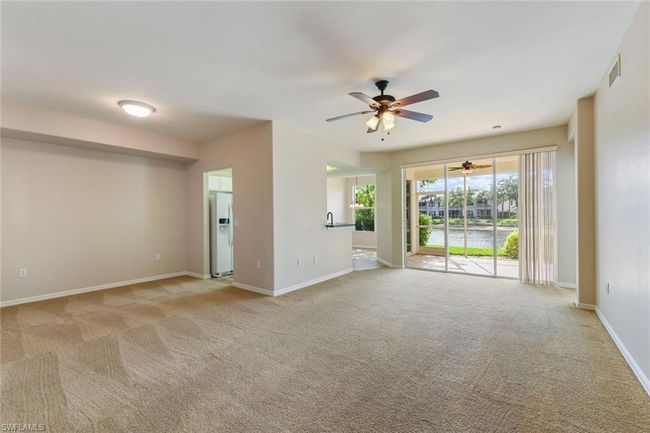Unfurnished living room featuring visible vents, carpet, baseboards, and ceiling fan | Image 12