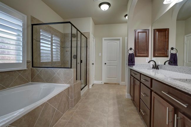 Full bathroom featuring a garden tub, a stall shower, double vanity, and tile patterned floors | Image 16