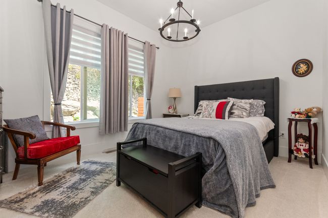 Bedroom with light carpet and a chandelier | Image 17