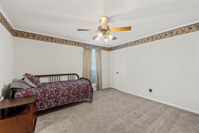 Carpeted bedroom with a ceiling fan, baseboards, and ornamental molding | Image 23