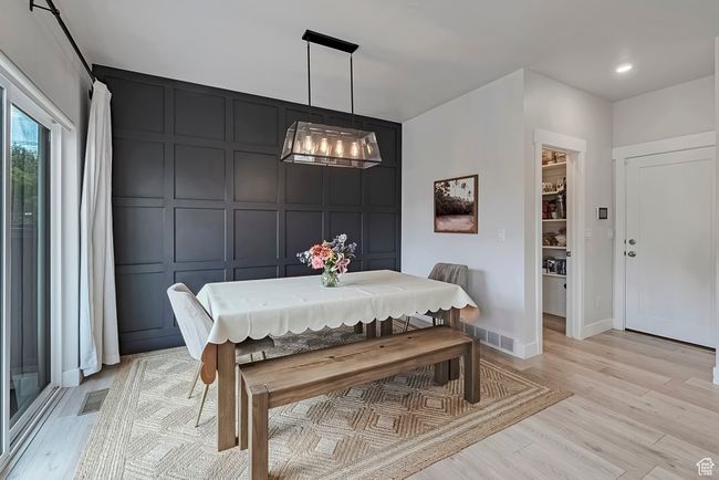 Dining area featuring a decorative wall, light wood finished floors, a chandelier, and baseboards | Image 8
