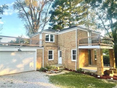 Rear view of property featuring a garage and a balcony | Image 1