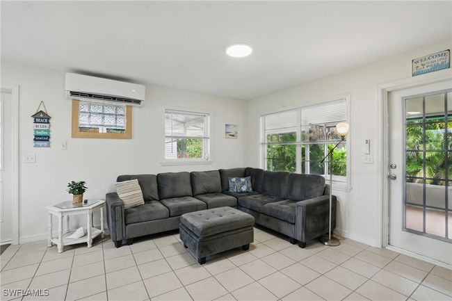 Living area with a wall mounted AC and light tile patterned floors | Image 17
