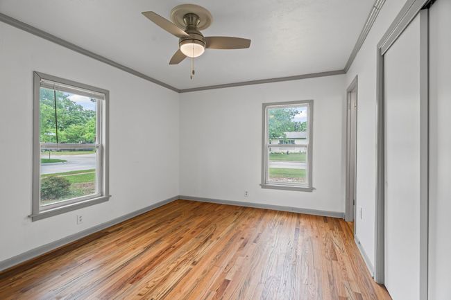Unfurnished bedroom with crown molding, light wood finished floors, a closet, and a ceiling fan | Image 27