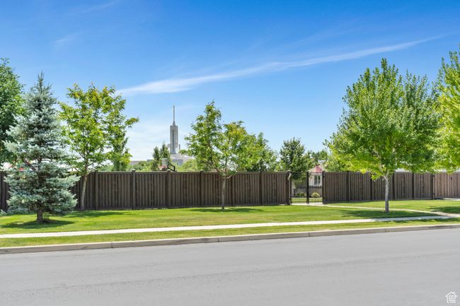 View of asphalt road with sidewalks, a gate, and curbs | Image 81