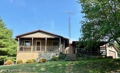 View of front of property with covered porch and a front lawn | Image 1