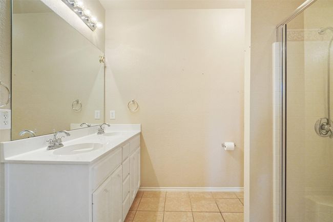 Primary bathroom featuring double vanity, a sink, a tile shower, and tile patterned flooring | Image 18
