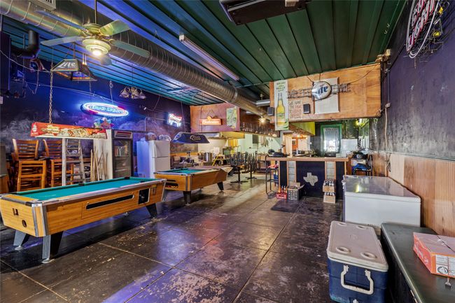 Game room with ceiling fan, billiards, and wooden walls | Image 13