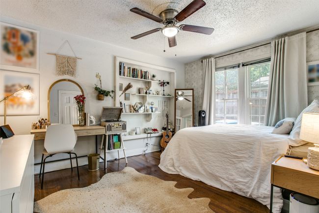 Bedroom with ceiling fan, a baseboard radiator, wood finished floors, a textured ceiling, and access to outside | Image 17