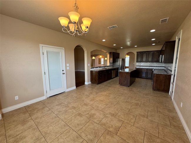 Kitchen featuring visible vents, arched walkways, and freestanding refrigerator | Image 7