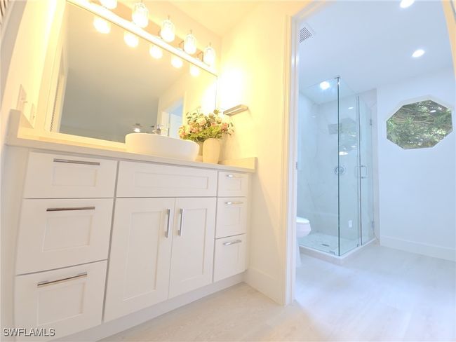 Full bathroom featuring baseboards, a marble finish shower, toilet, vanity, and wood finished floors | Image 19