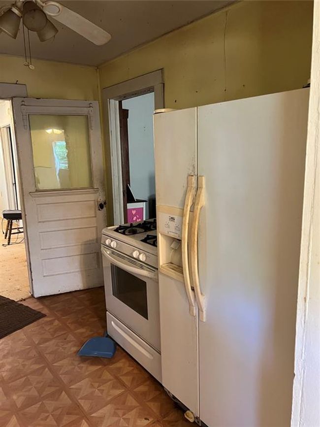 Kitchen featuring white fridge with ice dispenser, ceiling fan, range, and parquet flooring | Image 18