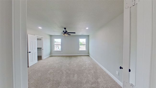 Unfurnished room with light carpet, ceiling fan, baseboards, and a textured ceiling | Image 13