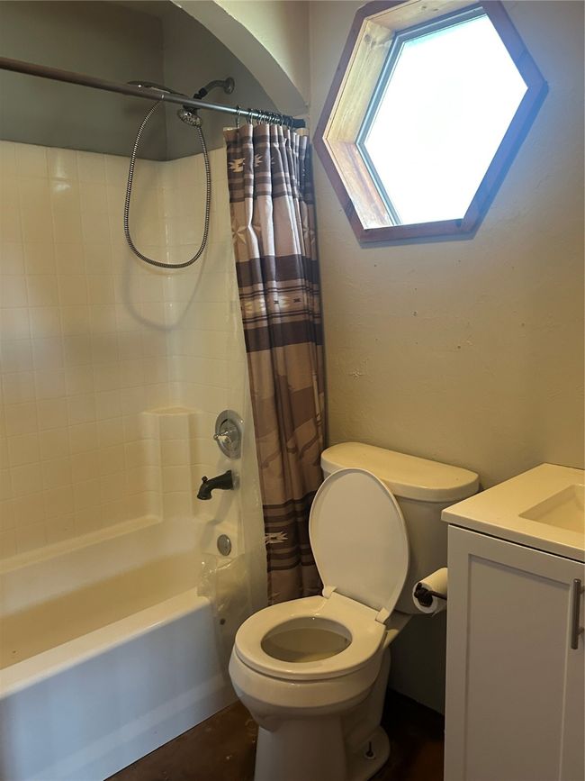 Bathroom featuring toilet, shower / tub combo, vanity, and a skylight | Image 11