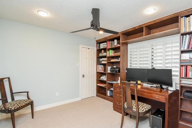Located just off the game room is the smallest of the 5 bedrooms. With it's built in shelving unit, it currently serves as an office. | Image 34