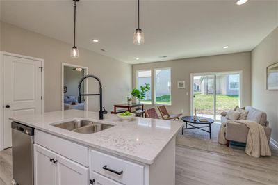 Kitchen featuring sink, a healthy amount of sunlight, stainless steel dishwasher, and white cabinetry | Image 2