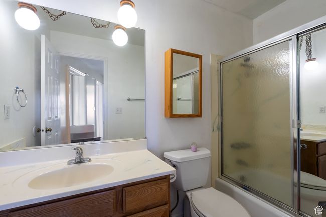 Bathroom with combined bath / shower with glass door, toilet, and vanity | Image 19